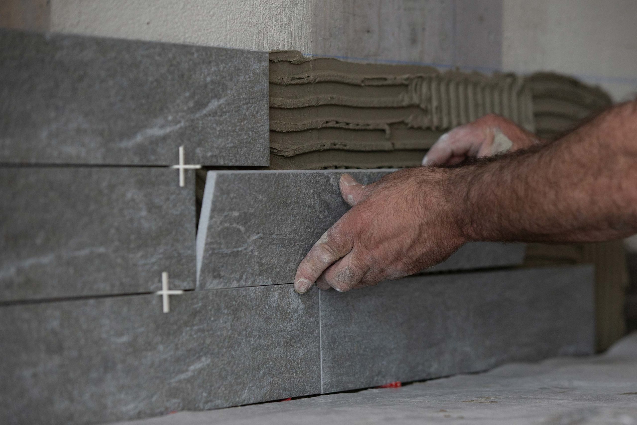 Carreleur qui pose un carrelage de petit format